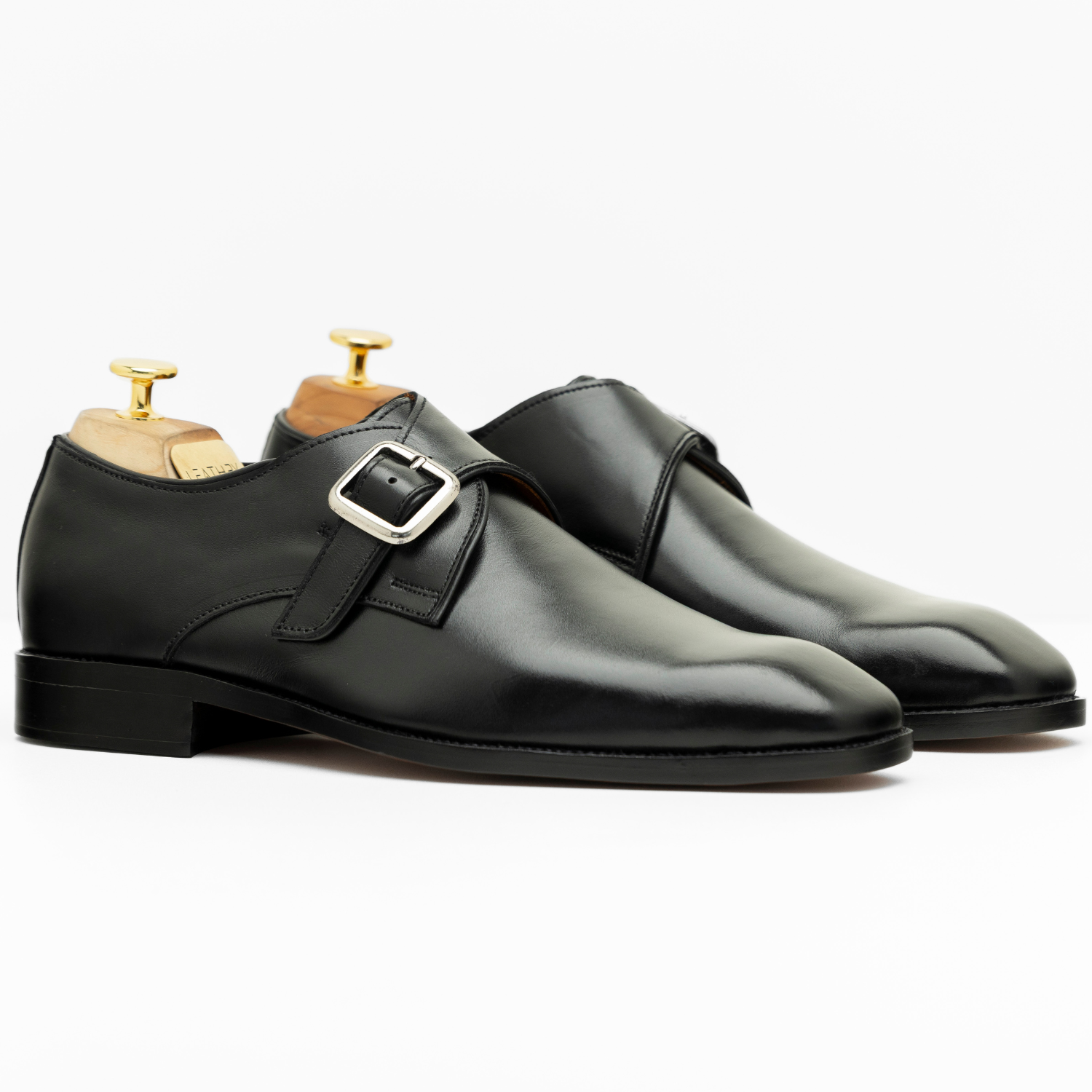 Pair of black monk strap shoes on a white background