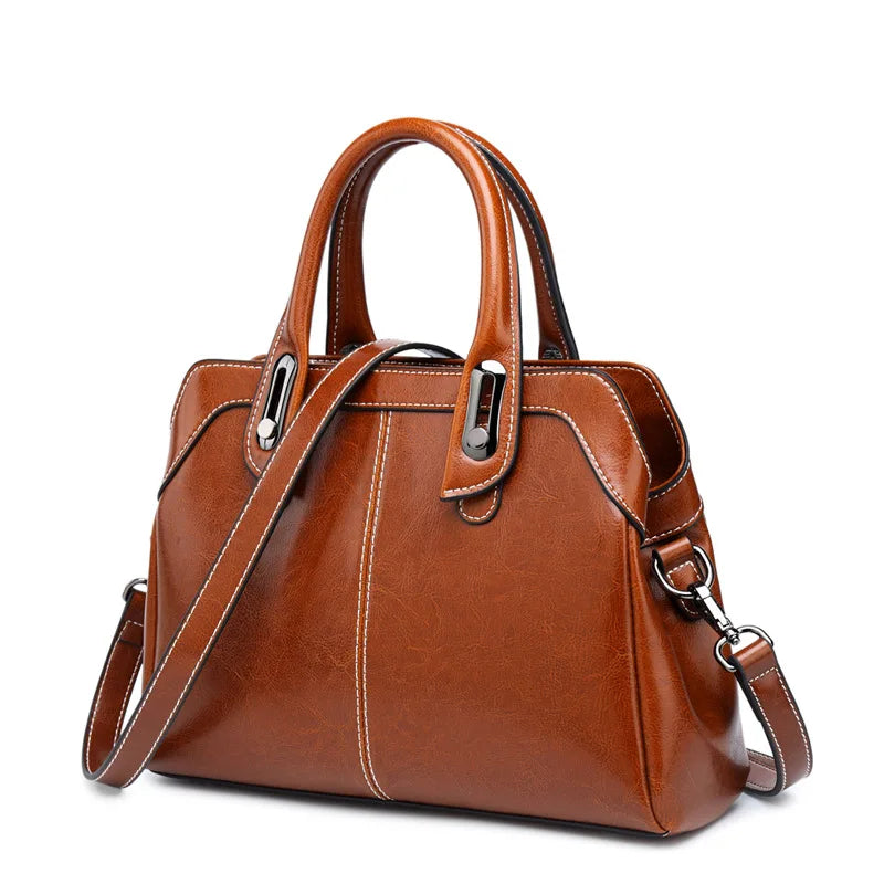 Brown leather handbag with a shoulder strap on a white background