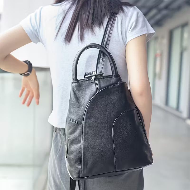 Person wearing a black leather backpack in an indoor setting