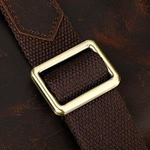 Brown belt with a gold buckle on a dark brown leather background